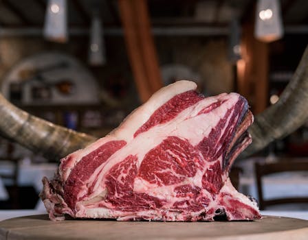 High-quality marbled beef rib displayed on a rustic wooden table, showcasing its raw texture and rich colors.